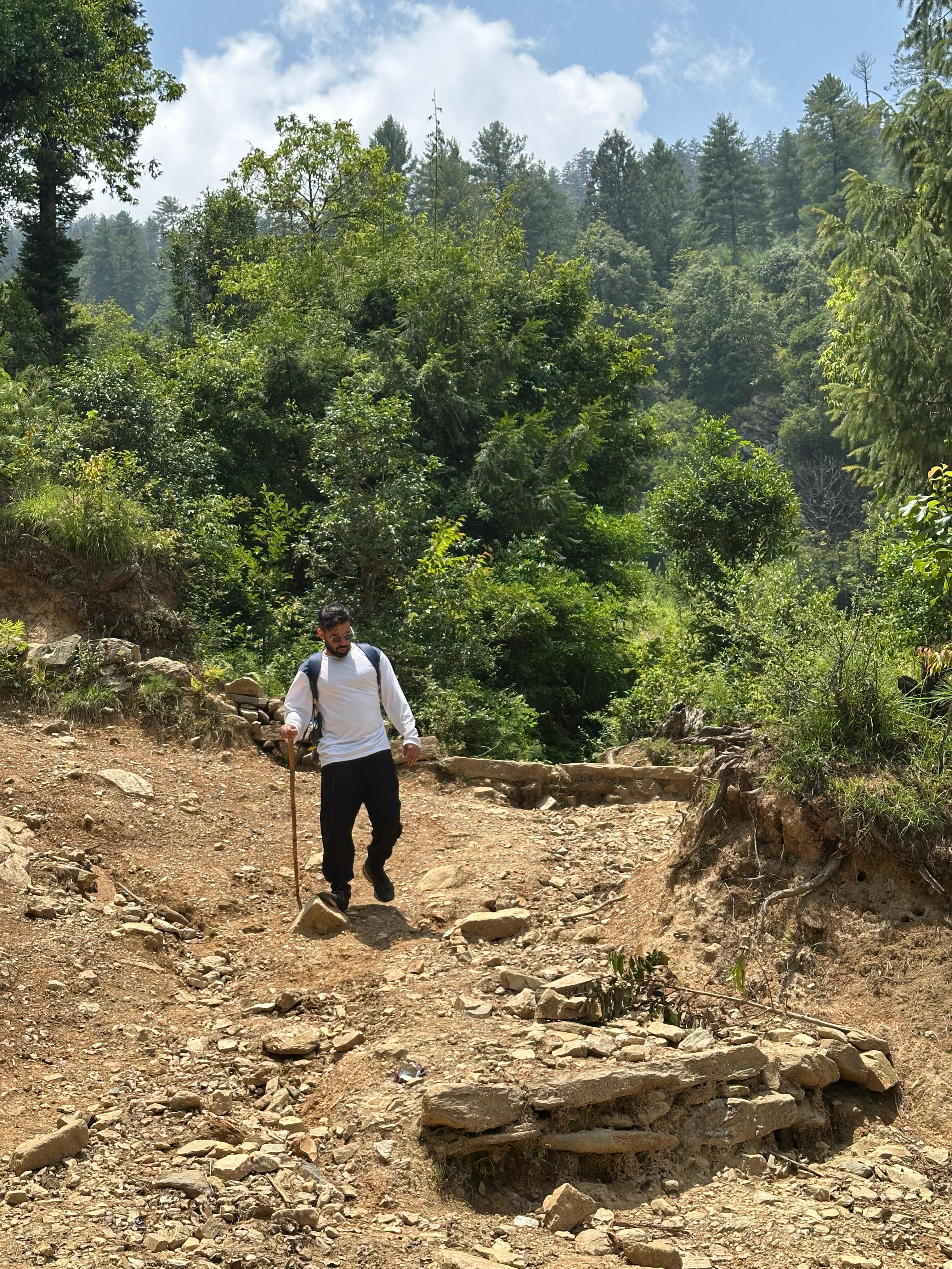 Traveller trekking along a mountain trail while creating authentic travel content